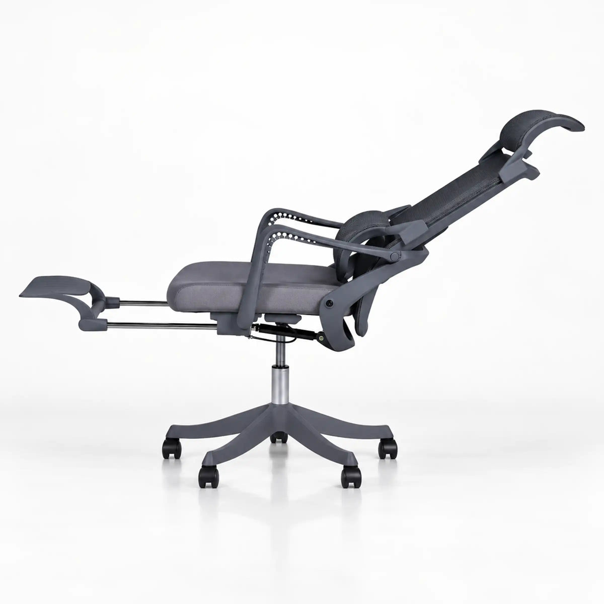 A modern dark gray adjustable recliner chair with a five-star wheeled base, shown in a side profile view against a clean white background.