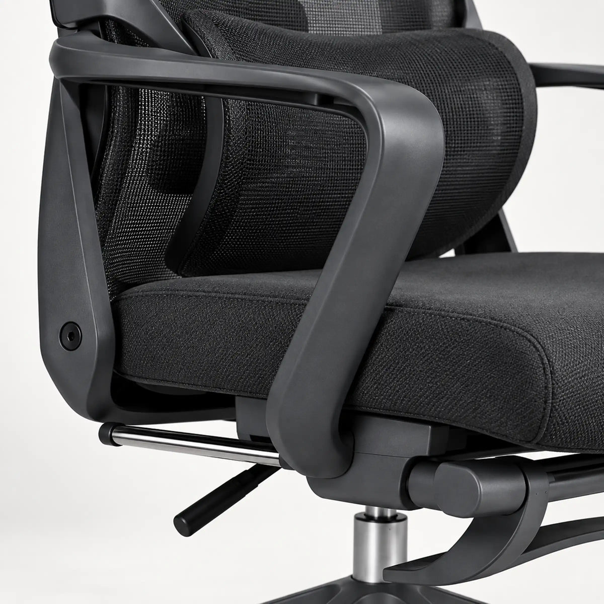 Close-up of a black mesh office chair with a padded seat and curved armrests on a light gray background.