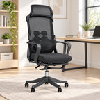 A black mesh ergonomic office chair with a headrest, lumbar support, and five-wheel casters, positioned in a bright, modern home office next to a wooden desk.