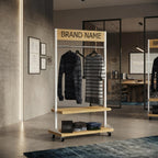 Compact Retail Stand with custom brand header, garment rail, display shelves and wheels for modern clothing stores.