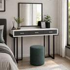 Crystal dressing table with three drawers, black metal legs and teal stool in a modern bedroom