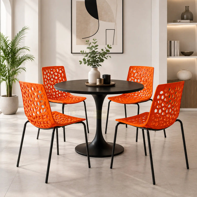 Four orange Lattice Outdoor Chairs around a black round dining table in a modern home, cafe or restaurant seating setup.