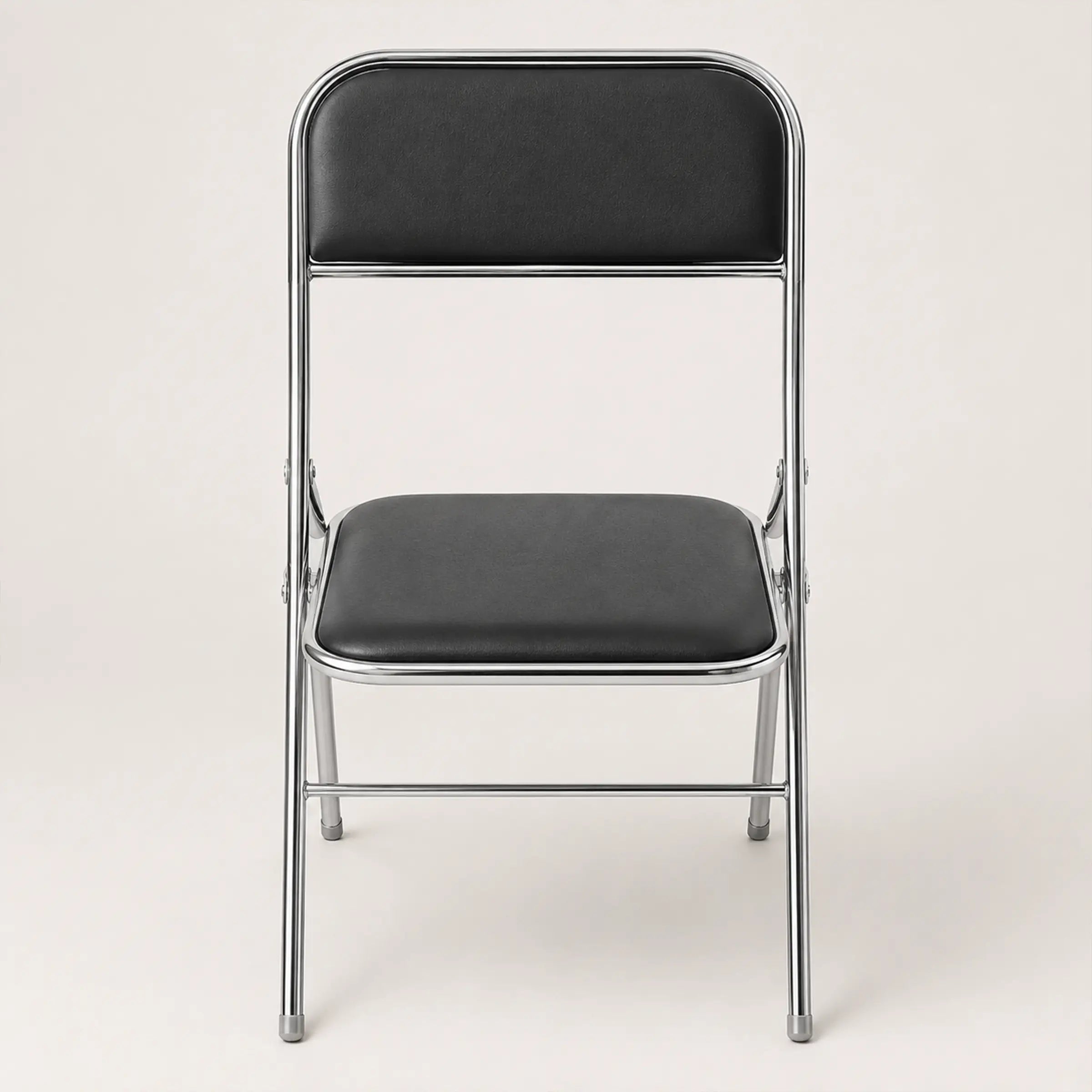 Shai Folding Chair with black padded seat and backrest, chrome metal frame and compact foldable design.