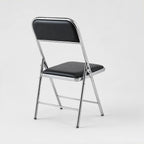 Front view of Shai Folding Chair with black padded seat, supportive backrest and durable chrome metal frame.