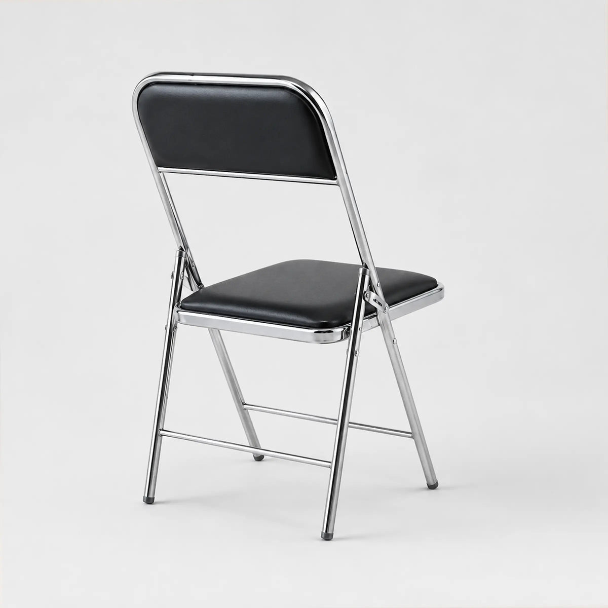 Front view of Shai Folding Chair with black padded seat, supportive backrest and durable chrome metal frame.