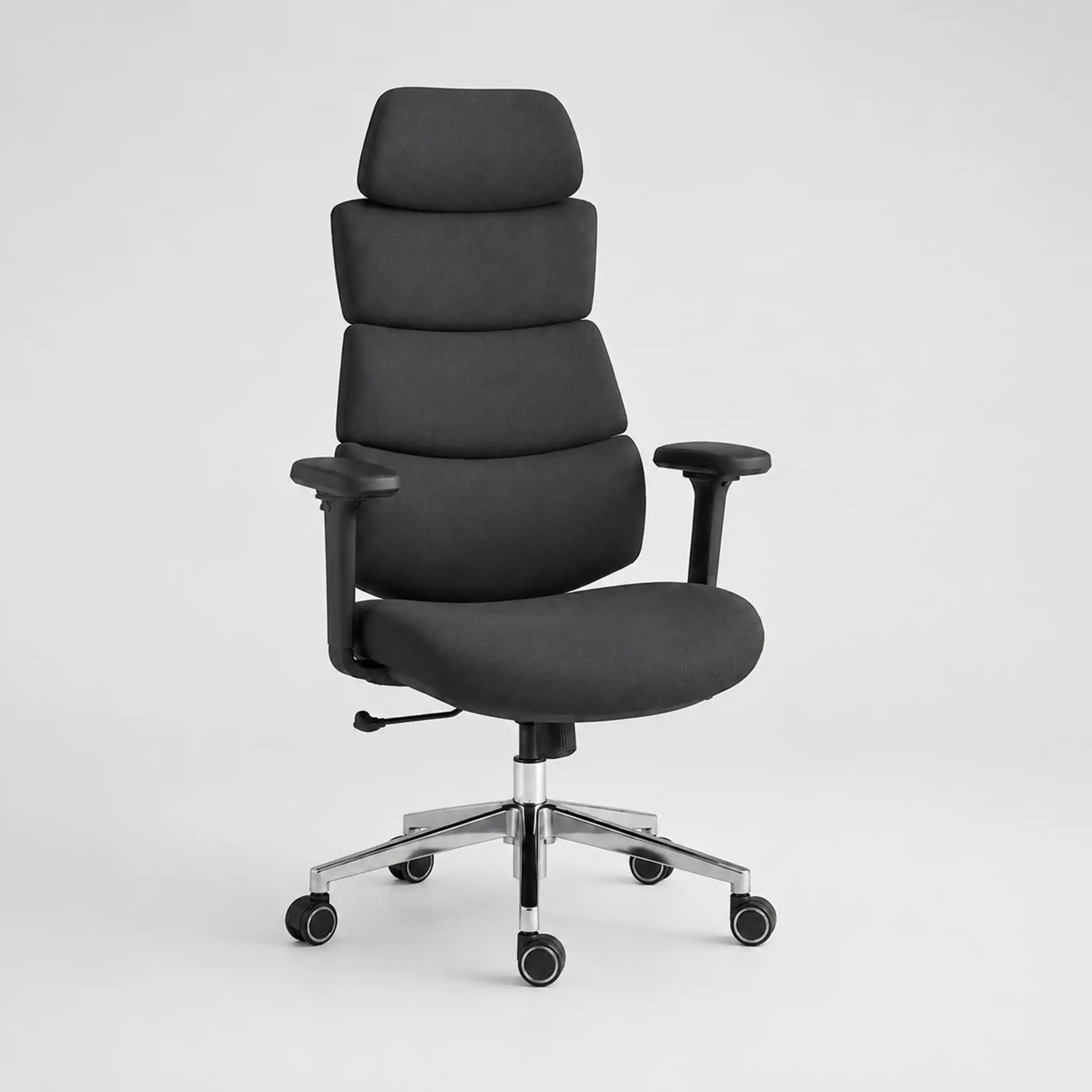 A high-back office chair with padded segmented backrest, black fabric upholstery, adjustable armrests, and a chrome five-star wheeled base, shown on a light gray studio background.
