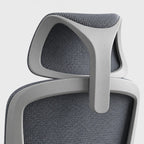 Close-up of an ergonomic office chair showing the headrest and upper backrest with gray textured mesh fabric and a light gray frame.