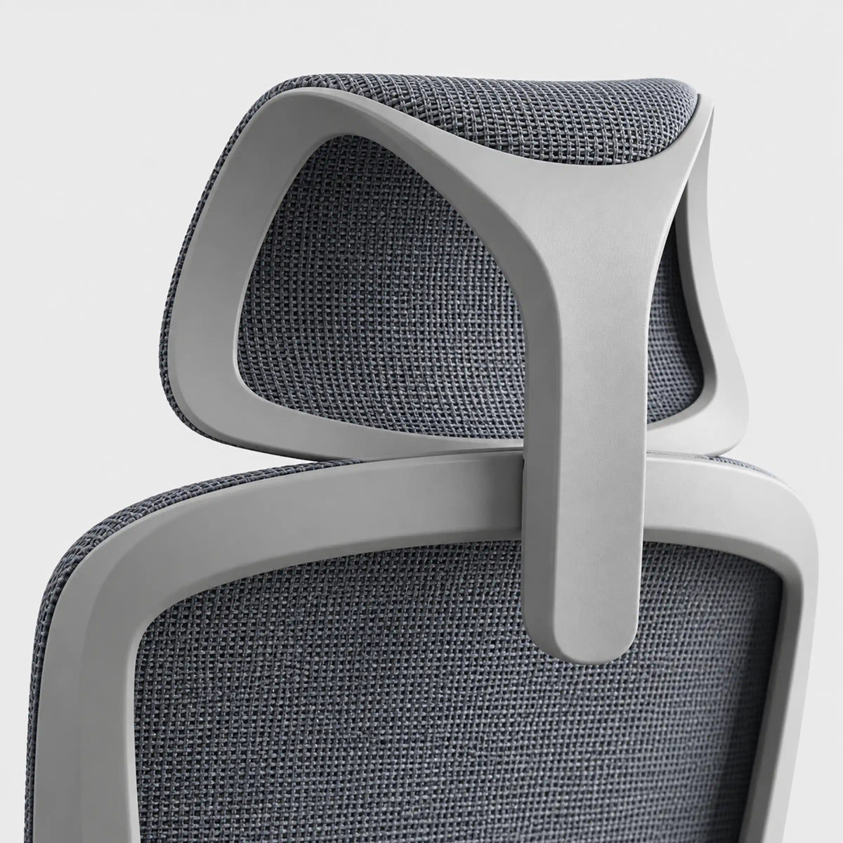 Close-up of an ergonomic office chair showing the headrest and upper backrest with gray textured mesh fabric and a light gray frame.