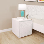 White Astro bedside cabinet with geometric door pattern and lamp beside a bed