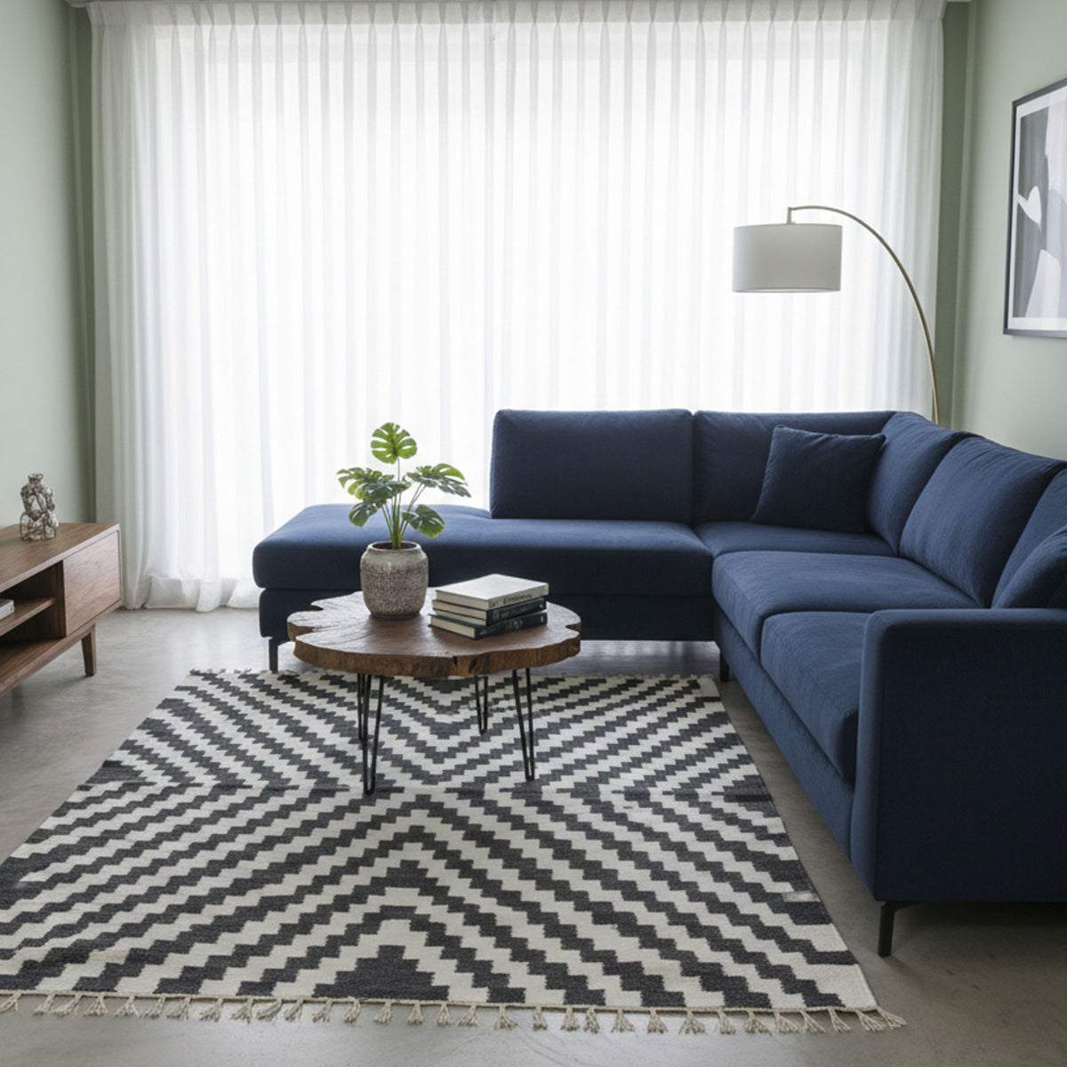 Black and white Rova zigzag rug beneath a round table beside a blue sofa