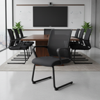 Black Estive visitor chair with mesh back and sled base in a meeting room