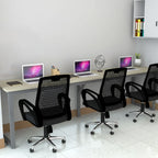 Eclectic workstation with laptops and three black mesh chairs, close angled view