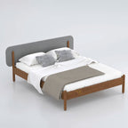 Brown Hauser bed with grey padded headboard and pale bedding, angled view