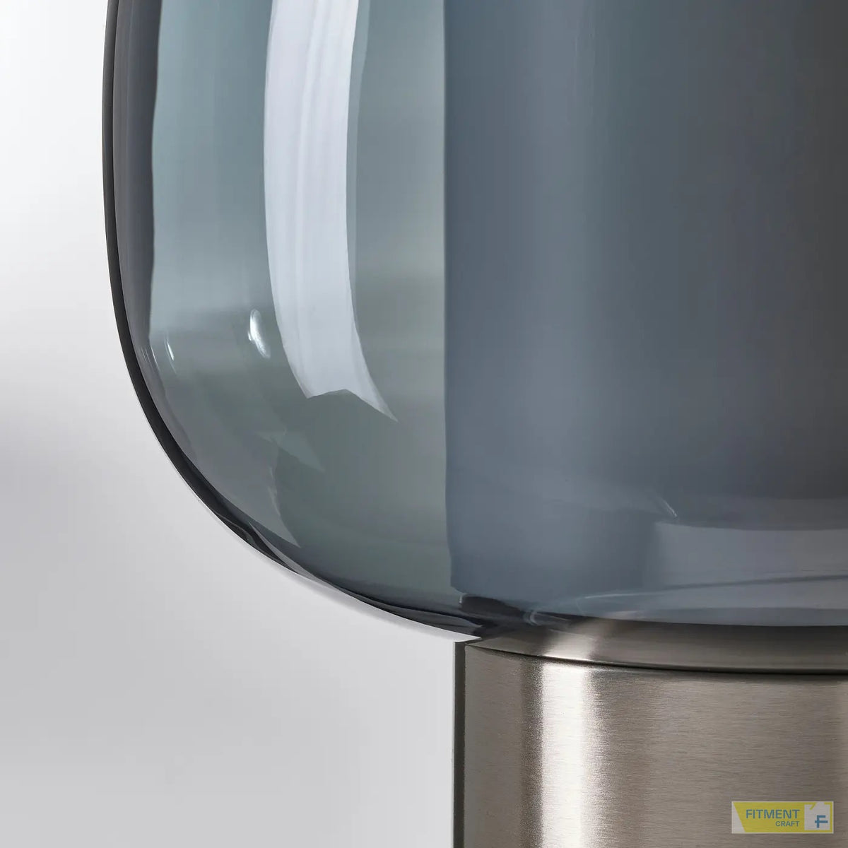 Close-up of HÖGVIND grey glass shade and base