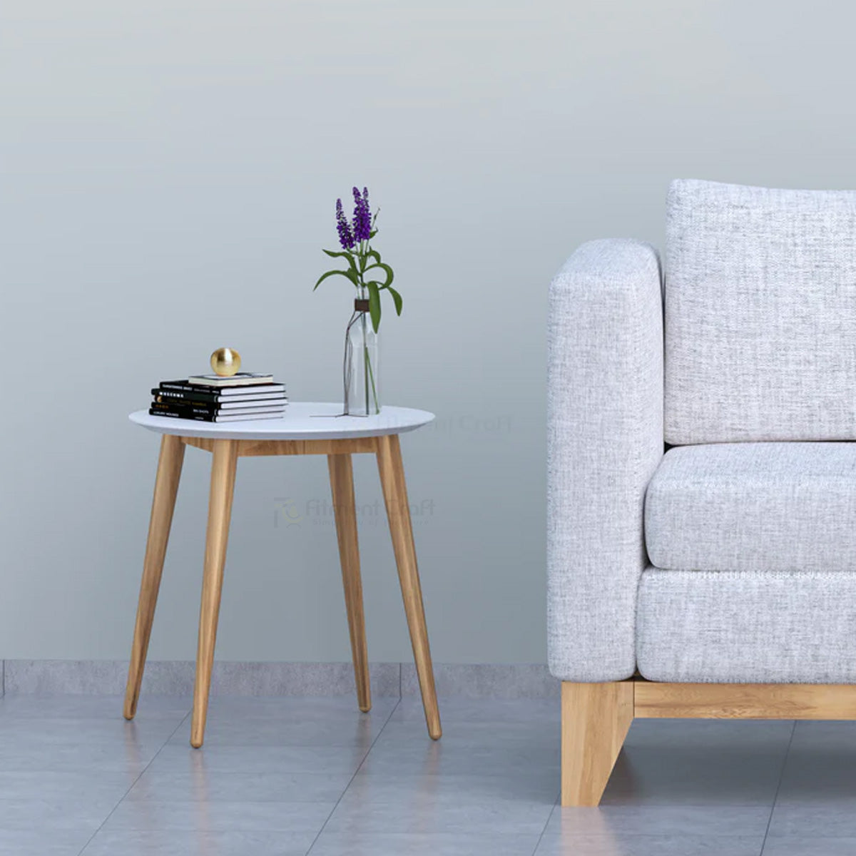 Hollow round side table with pale top and tapered wood-tone legs beside a sofa