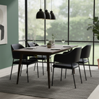 Dark Nadra dining chairs arranged around a table beside large windows