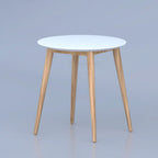 Round Hollow table with white top and three tapered wood-tone legs
