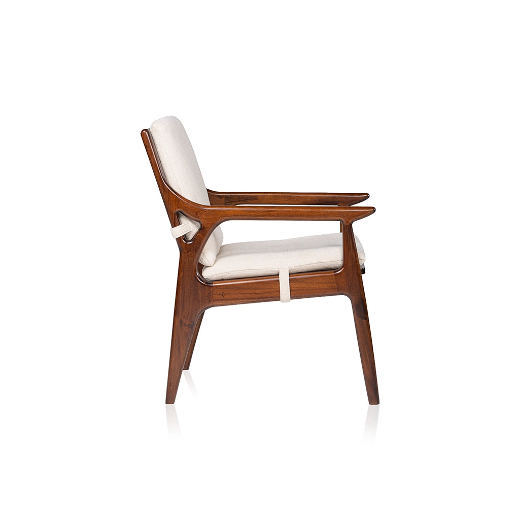Side view of the Walden wooden lounge chair showing curved armrests, cream seat and back cushions, and cushion straps.
