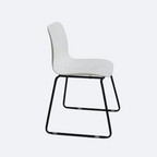 White Cathedra chair side view with curved seat and black sled legs