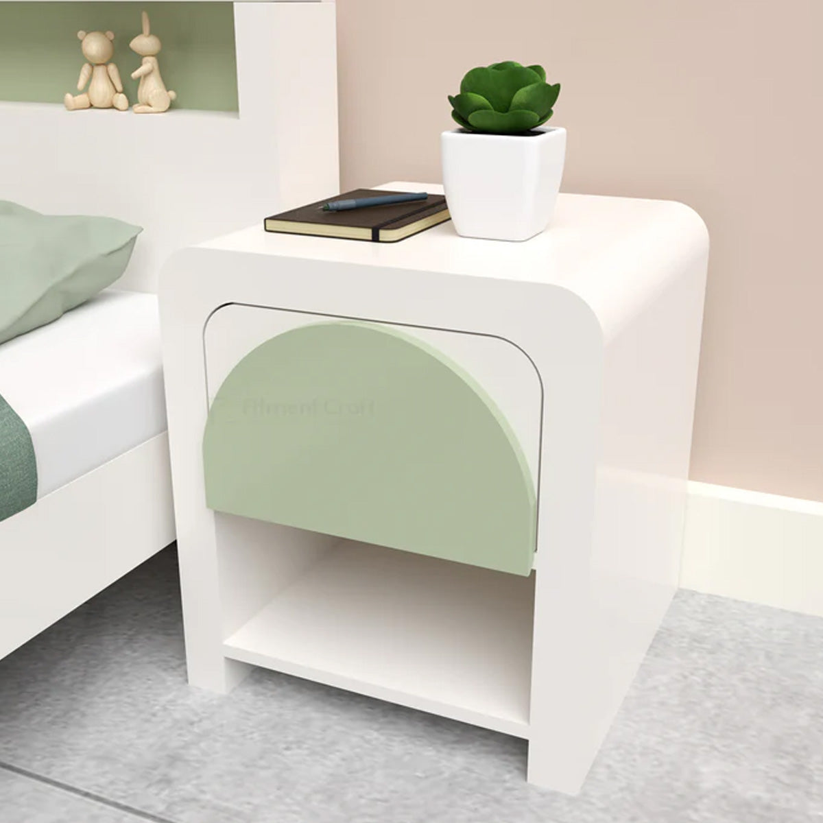 White Ortho bedside table with pale green drawer front beside a bed